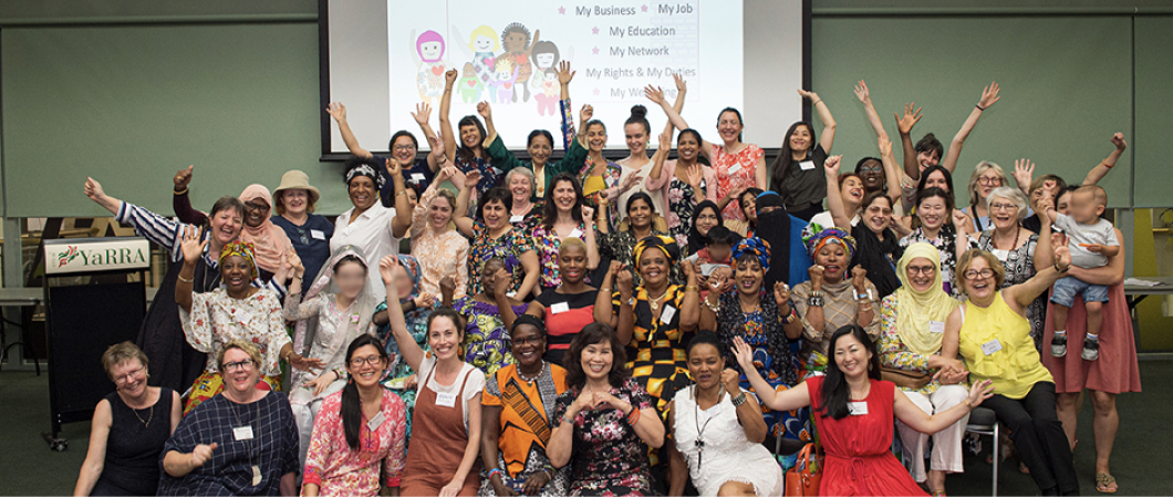 A large group of women smiling at camera who are part of Sisterworks, an organisation that also makes an impact on women's lives. 